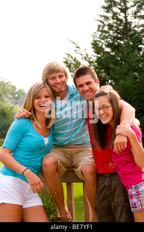 Moderno e gli adolescenti di età compresa tra 14 a 18 appendere fuori a casa insieme come amici al di fuori in giardino Foto Stock