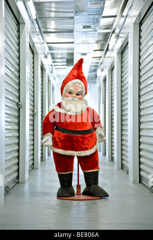 Un anni sessanta era farcito di Santa Claus si trova in un corridoio industriale dentro la sua auto unità di storage Foto Stock