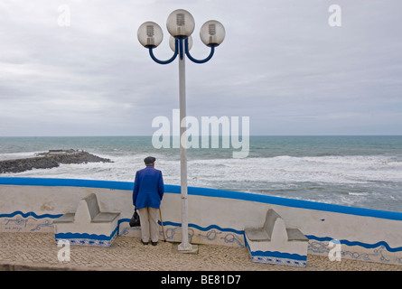 Il vecchio uomo, titolare di pensione o di rendita che guarda al mare, storico, antico villaggio di pescatori, Ericeira portogallo, Atlantico Foto Stock