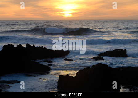 Onde che si infrangono sulle rocce al tramonto, vicino alla spiaggia di Guincho, Costa de Lisboa, distretto di Lisbona, Estremadura, Portogallo, Atlantico Foto Stock
