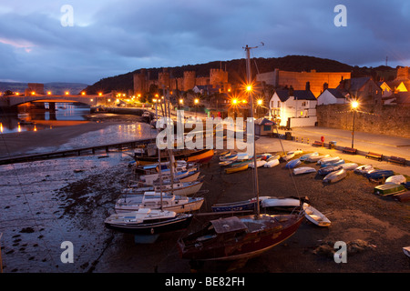 Conwy harbour scena prima la luce del mattino, con i lampioni che splende su barche e Jetty. Foto Stock