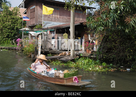 La donna in un longtail boat sul modo per il mercato galleggiante di Bangkok, Tailandia Foto Stock