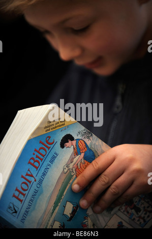 Un bambino la lettura di una Bibbia a una scuola domenicale di Regno Unito Foto Stock