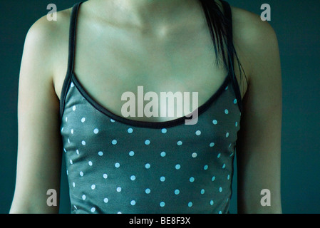 Ragazza adolescente che indossa la polka dot tank top, ritagliato Foto Stock