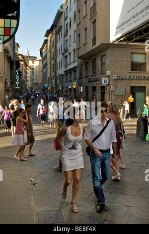 Una giovane coppia di passeggiare lungo la Via Por Santa Maria appena prima che i molti negozi di gioielli su Ponte Vecchio a Firenze. Foto Stock