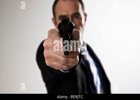 L uomo indossa una tuta, tenendo in mano una pistola Foto Stock