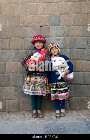 Perù Cusco, Sito Patrimonio Mondiale dell'UNESCO, due ragazze Inca holding baby agnelli Foto Stock