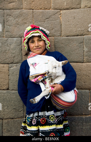 Il Perù, Cuzco, Sito Patrimonio Mondiale dell'UNESCO, ragazza giovane azienda agnellino Foto Stock