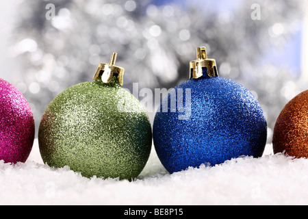 Colorate baubles di Natale sulla neve in atmosfera festosa Foto Stock