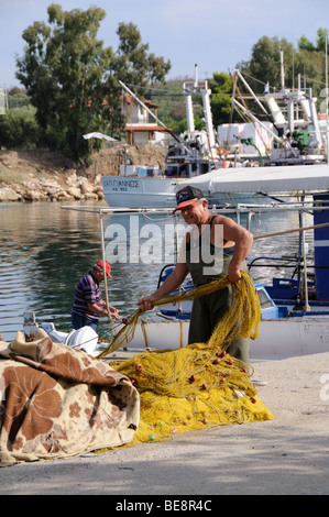 Pescatore reti di smistamento sulla banchina nel piccolo villaggio di pescatori di Nea Potidea sulla penisola di Kassandra Calcidica Grecia Foto Stock