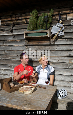 Noleggio racers prendendo una pausa con il sud speck tirolese e degustazione di vini presso il Mountain Lodge il passo di Pennes, alto adige, ita Foto Stock