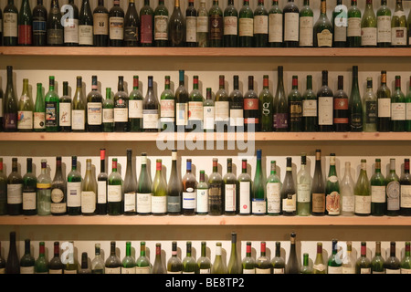 Tante vuote le bottiglie di vino sugli scaffali nella finestra di un vino ristorante, Vienna, Austria, Europa Foto Stock