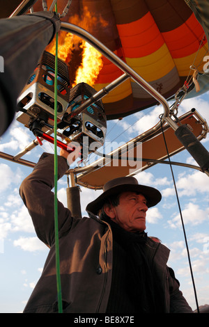 Mongolfiera pilota controlla l'altitudine mediante cottura di bruciatori (Namibia) Foto Stock