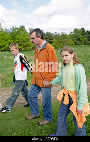 Un padre e i suoi due bambini di andare a fare una passeggiata in Jegum, Danimarca Foto Stock
