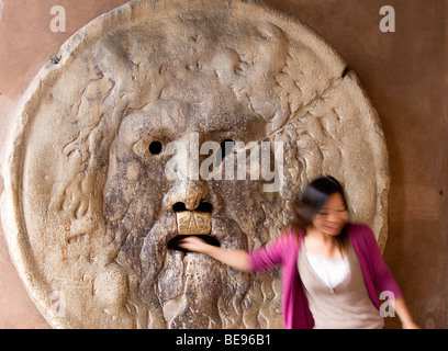 Italia Roma Lazio donna con la sua mano nelle ganasce della Bocca della Verita' o la Bocca della Verità Foto Stock