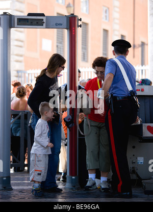 Italia Lazio Roma Città del Vaticano Le donne con un giovane ragazzo di dispositivi di sicurezza a raggi x verificare presidiata da un poliziotto Carabiniere Foto Stock