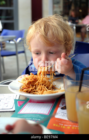Ragazzo giovane mangiare spaghetti bolognese Foto Stock