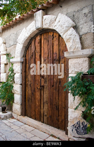 Croazia; Hrvartska; Kroatien, Isola di Hvar; Strai Grad, di età compresa tra porta di legno, con sommità arrotondata, nel muro di pietra Foto Stock
