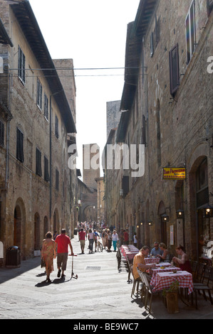 Street cafe su Via San Matteo, uno dei principali nel centro storico di San Gimignano, Toscana, Italia Foto Stock