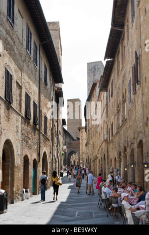 Via San Matteo, uno dei principali nel centro storico di San Gimignano, Toscana, Italia Foto Stock