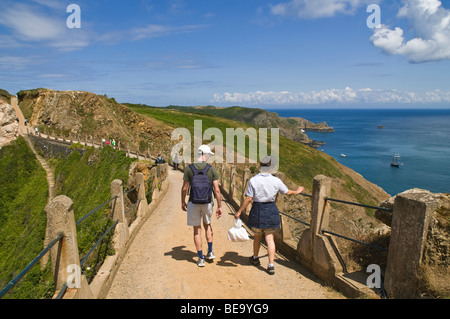 dh la Coupée Causeway LA Coupée SARK ISLAND turisti a piedi coppia turistica strada canale isola passeggiata attraverso istmo Foto Stock