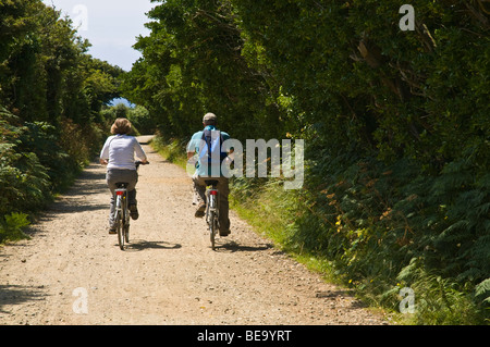 dh SARK SARK ISLAND due coppie di turisti in bicicletta in piste di campagna ciclismo strada canale isole 2 ciclisti ciclisti ciclisti vacanze cicli Foto Stock