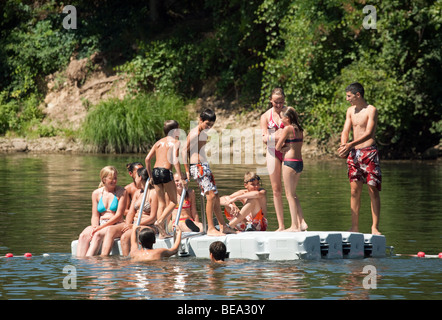 Adolescenti che giocano su un pontone galleggiante nel fiume Lot, Castelmoron, Aquitaine, Francia Foto Stock