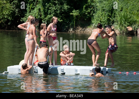 Adolescenti che giocano su un pontone galleggiante nel fiume Lot, Castelmoron, Aquitaine, Francia Foto Stock