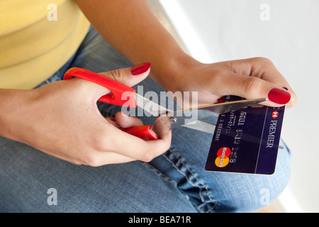 Donna di taglio a mano una carta di credito, close up Foto Stock