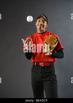 Razza mista giocatore di baseball di baseball tossing Foto Stock