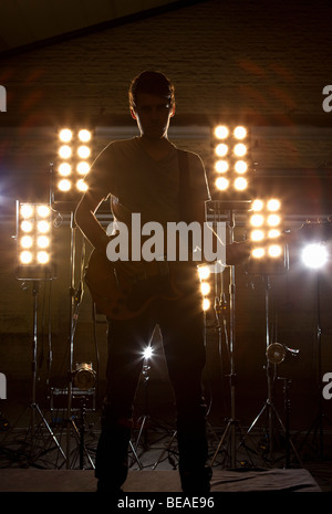 Un musicista rock suonando una chitarra su un palco Foto Stock
