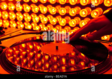 Un DJ scratching un record in una discoteca Foto Stock