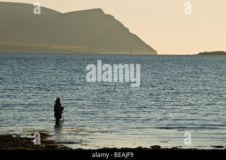Dh pescatore pesca flusso SCAPA ORKNEY Wading fisherman asta off shore sera Hoy colline Scozia Scotland Foto Stock
