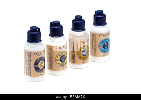 Quattro bottiglie di plastica di uno di ciascuno L'Occitane shampoo, balsamo, crema per il corpo e doccia crema Foto Stock