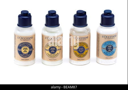 Quattro bottiglie di plastica di uno di ciascuno L'Occitane shampoo, balsamo, crema per il corpo e doccia crema Foto Stock
