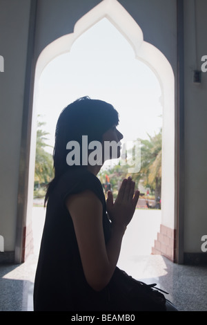 Donna asiatica pregando nel tempio Foto Stock