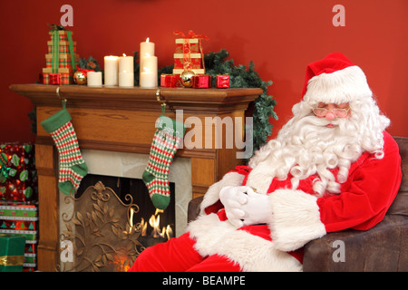 Babbo Natale dorme in poltrona Foto Stock