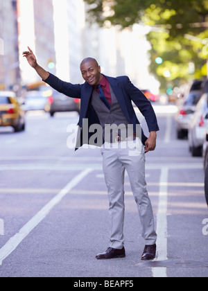 Imprenditore africano salutando taxi Foto Stock