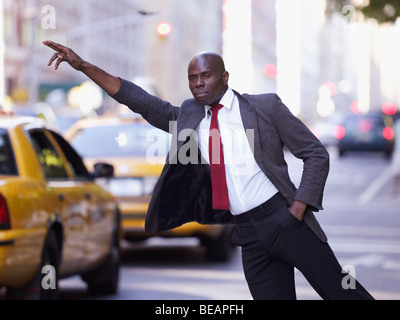 Imprenditore africano salutando taxi Foto Stock