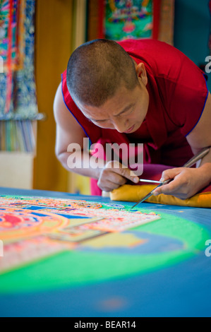 Monaco tibetano Yeshi Choedup opere attentamente su un coloratissimo Mandala di sabbia in Ruidoso, Nuovo Messico. Foto Stock