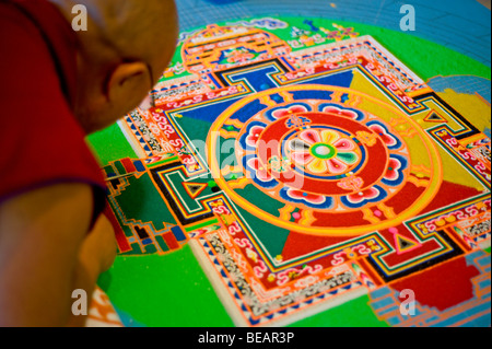 Monaco tibetano VenoDhondup Tsering opere attentamente su un coloratissimo Mandala di sabbia in Ruidoso, Nuovo Messico. Foto Stock