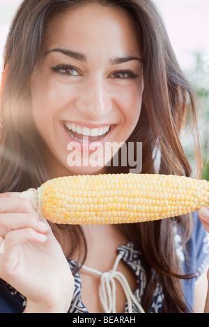 Donna ispanica mangiare spiga del granoturco Foto Stock