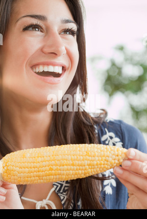 Donna ispanica mangiare spiga del granoturco Foto Stock