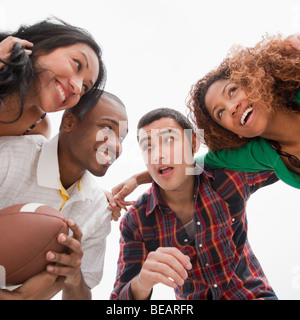 Amici tenendo il calcio in huddle Foto Stock