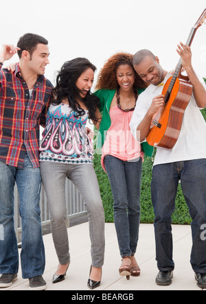 Amici a suonare la chitarra Foto Stock