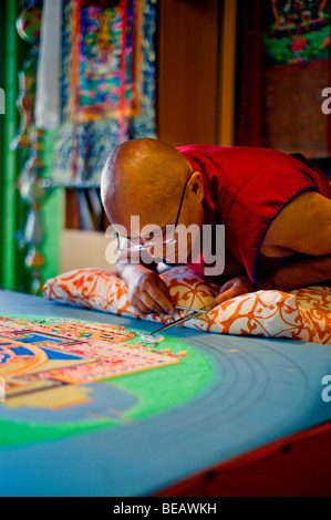 Monaco tibetano VenoDhondup Tsering opere attentamente su un coloratissimo Mandala di sabbia in Ruidoso, Nuovo Messico. Foto Stock