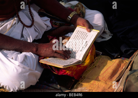 India, Uttarakhand, Haridwar, uomo che prega, testo indù Foto Stock