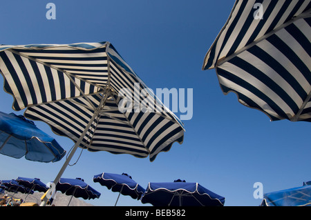 Striata ombrelloni su un isola greca offrono riparo dal sole Foto Stock