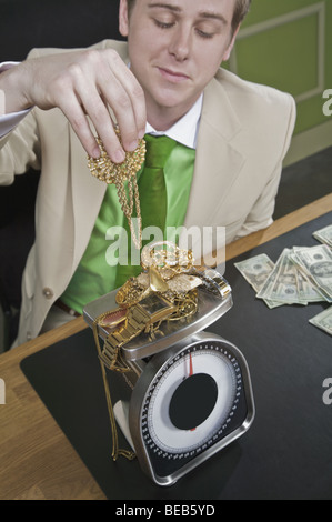 Imprenditore del peso di gioielleria in oro Foto Stock
