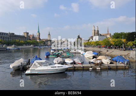 Imbarcazioni da diporto ormeggiato sul fiume Limmat a Zurigo con le guglie gemelle su Grossmünster in background. Foto Stock